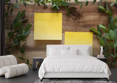 Two post-its on a wooden background surrounded by a leafy green frame.  Wall mural