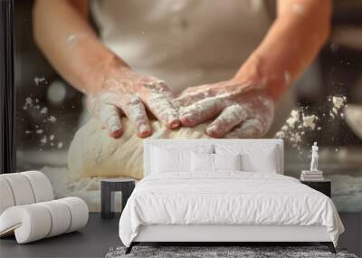 A baker kneads dough preparing it for baking fresh bread against blurred bakery background. Wall mural