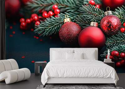 Red Christmas ornaments and fir branches with berries on a dark background, perfect for festive holiday designs. Wall mural