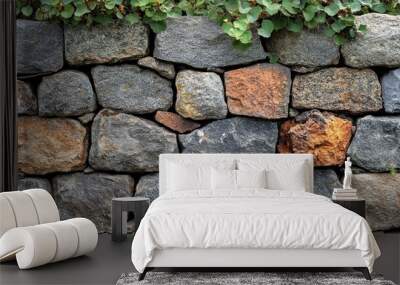 A textured stone wall with greenery at the top. Wall mural