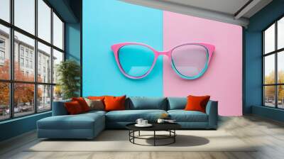 Vibrant Pink Sunglasses on a Dual-Tone Blue and Pink Background for Summer Fashion Wall mural