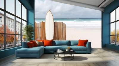 Surfboard near a wooden fence on the beach. Wall mural