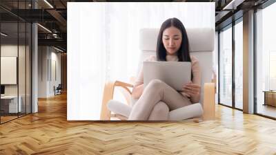 beautiful lady is working on laptop on chair with windows light copy space Wall mural