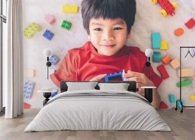 Happy boy surrounded by colorful toy blocks with open heart windows Wall mural