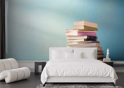 Many books on a wooden table and a pastel blue background. back to school. Education. Generative AI. Wall mural