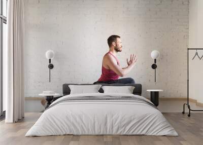 Man doing yoga in fitness studio, selective focus. Wall mural