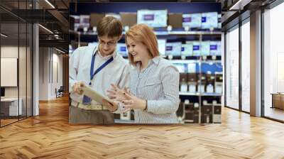 the seller-adviser shows the girl a new tablet computer Wall mural