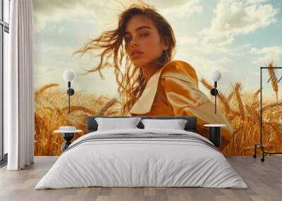 A female model posing in a wheat field, wearing a stylish outfit, surrounded by golden wheat under a bright summer sky, capturing a sense of elegance and freedom Wall mural