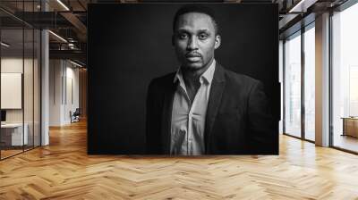 Black and white portrait of attractive, beautiful, serious and stylish professional African American businesswoman in dark suit and white shirt isolated on dark background. Low key. Selective focus Wall mural