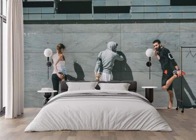 three friends athletes jogging in a modern building district Wall mural