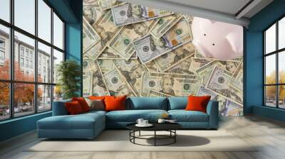 Piggybank surrounded by money resting on a table. Wall mural