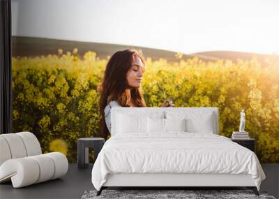 Young girl in yellow flower field Wall mural