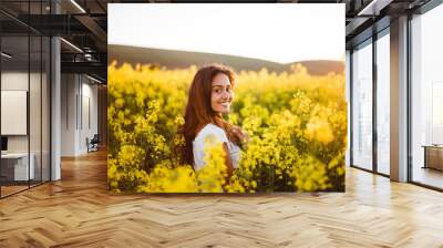 Young girl in yellow flower field Wall mural