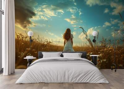 Young woman walking through field of flowers at sunset Wall mural