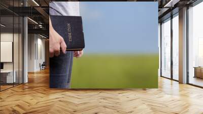 Standing Holding the Bible in a Field Wall mural