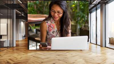 Young adult girl working on laptop in casual attire  Wall mural