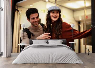 Beautiful couple at railway station waiting for the train. Young woman and man waiting to board a train Wall mural