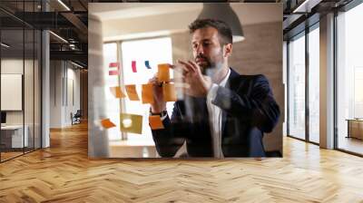 Businessman in conference room. Young businessman in suit making a business plan Wall mural