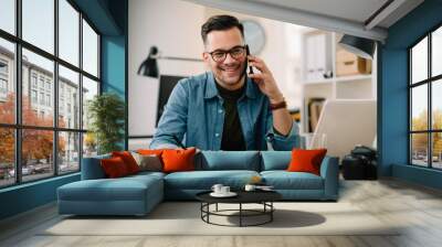 Businessman in office. Handsome man talking on phone at work Wall mural