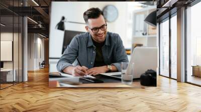 Businessman in office. Handsome man working on lap top. Wall mural