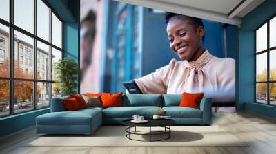 Businesswoman using the phone in cafe. African businesswoman with curly hair on coffee break. Wall mural