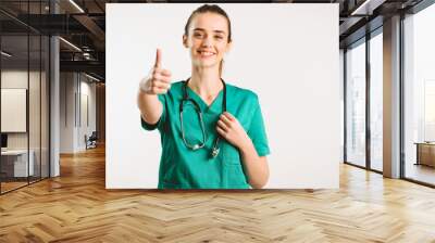 Cheerful female doctor in green uniform. Wall mural