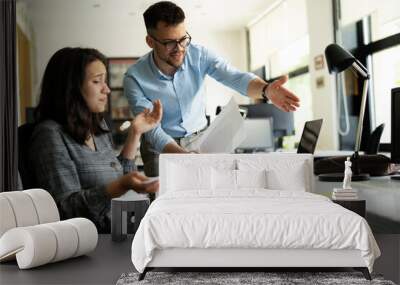 Colleagues arguing in office. Angry businessman yelling at his collegue. Wall mural