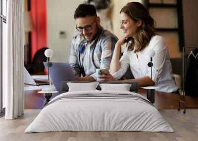 Colleagues drinking coffee in office. Businesswoman and businessman discussing work in office. Wall mural