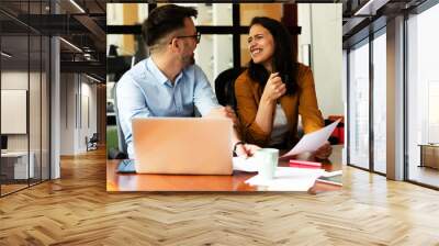 Colleagues in office. Businesswoman and businessman discussing work in office. Two friends in working together. Wall mural