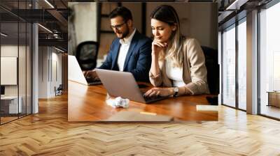 Colleagues in office. Businesswoman and businessman discussing work in office. Two friends working together.. Wall mural