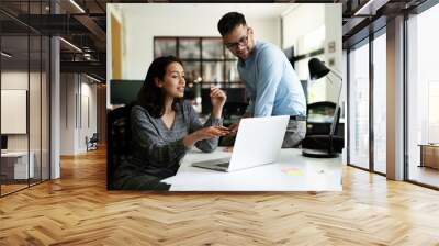 Colleagues in office. Businesswoman and businessman discussing work in office.. Wall mural