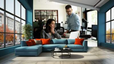 Colleagues in office. Businesswoman and businessman discussing work in office.. Wall mural