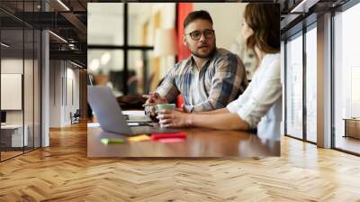 Colleagues in office. Businesswoman and businessman discussing work in office Wall mural