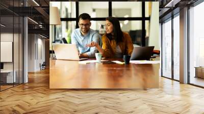 Colleagues in office. Businesswoman and businessman working together Wall mural