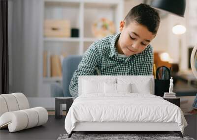 Cute little boy doing homework. Child learning foe school. Wall mural