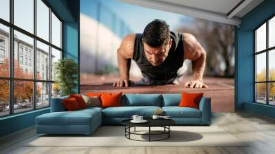 Fitness man doing push ups outdoor. Athlete training. Wall mural