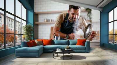 Handsome man preparing pasta in the kitchen. Guy cooking a tasty meal.. Wall mural