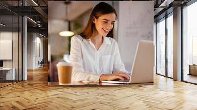 Happy businesswoman working on laptop Wall mural