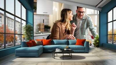 Happy smiling couple cooking together. Husband and wife preparing fresh pasta at home. Wall mural