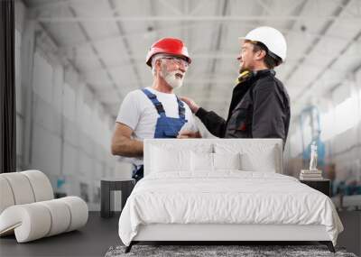 Portrait of workers in factory. Colleagues with helmet working in factory Wall mural