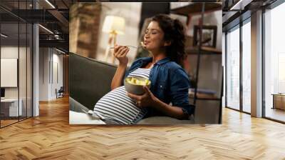 Pregnant woman eating fuit at home. Beautiful pregnant woman enjoy in healthy meal. Wall mural