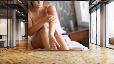 Woman applying body cream on her hand in bedroom. Close up Wall mural