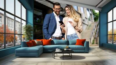 Young businesswoman and businessman standing on the street Beautiful businesswoman talking with her colleague Wall mural