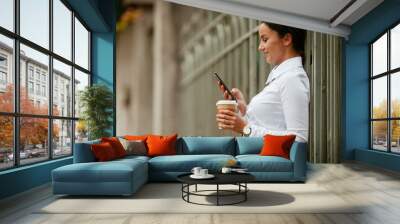 Young businesswoman using phone on coffee break Wall mural