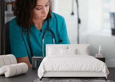 Young female doctor in medical office. Beautiful female doctor taking notes..  Wall mural