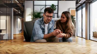 Young man having a problem. Girlfriend comforting her sad boyfriend. Wall mural