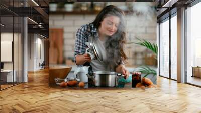 Young woman in kitchen. Beautiful woman preparing delicious food.  Wall mural