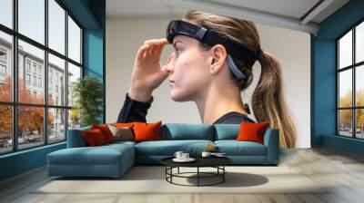 A person using a brainsensing headband to track their cognitive activity while completing various technologybased training exercises Wall mural