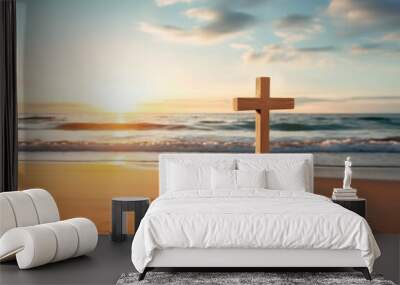 Concept photo of a calm and peaceful beach, with a simple wooden crucifix p in the sand, surrounded by seashells and with the sun rising behind it, reminding us of the timeless message of Wall mural