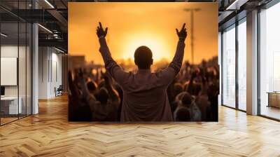 Concept photo of a man standing at the front of the prayer vigil, his hands raised towards the sky in a gesture of surrender, leading the group in a heartfelt prayer. Wall mural